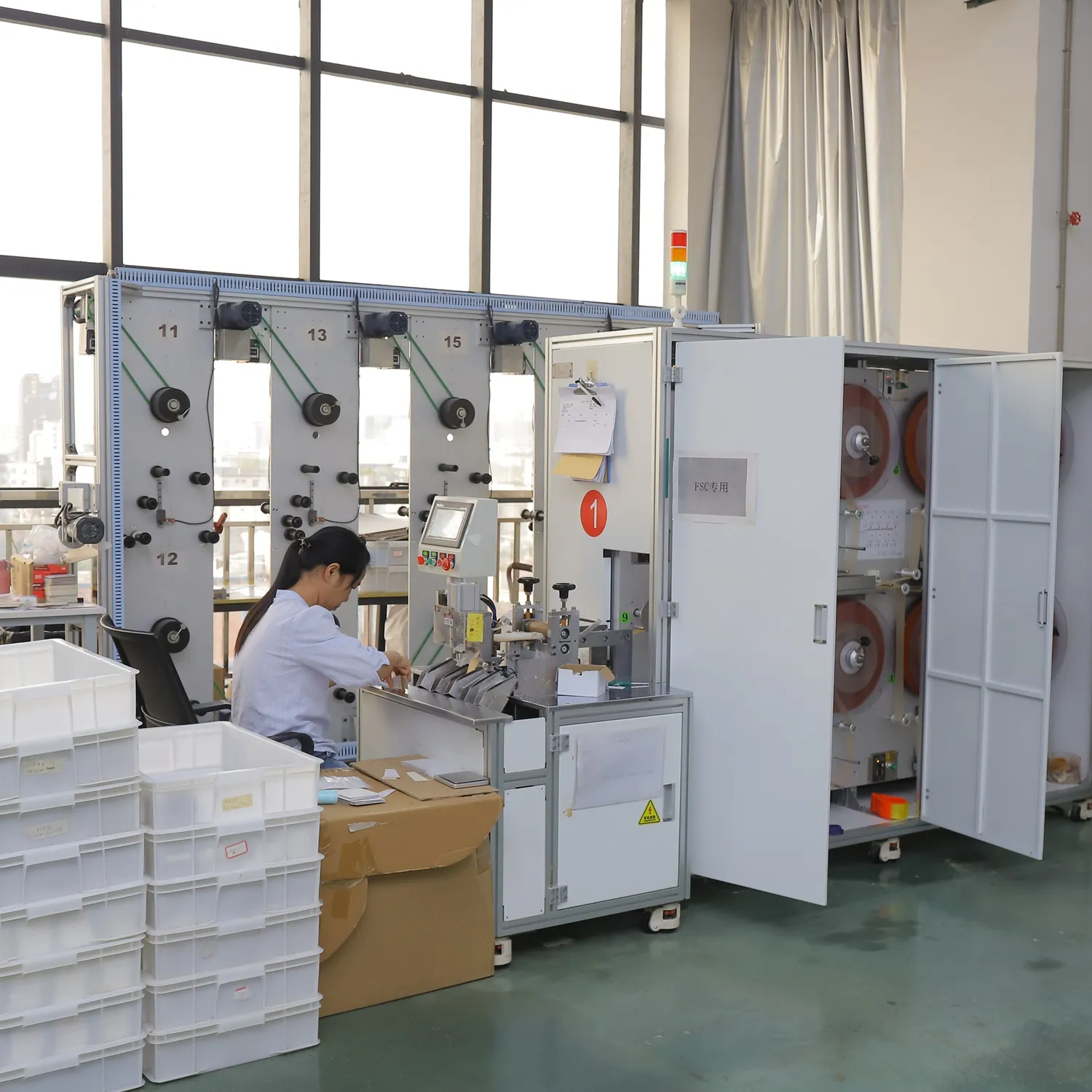 Operator working beside production machines and boxed materials