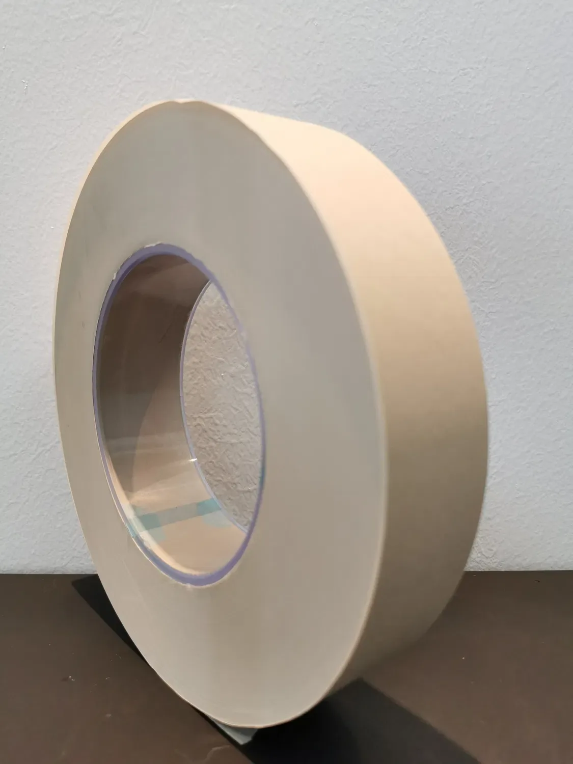 Industrial bobbin of natural-tone rolling paper stock on factory floor