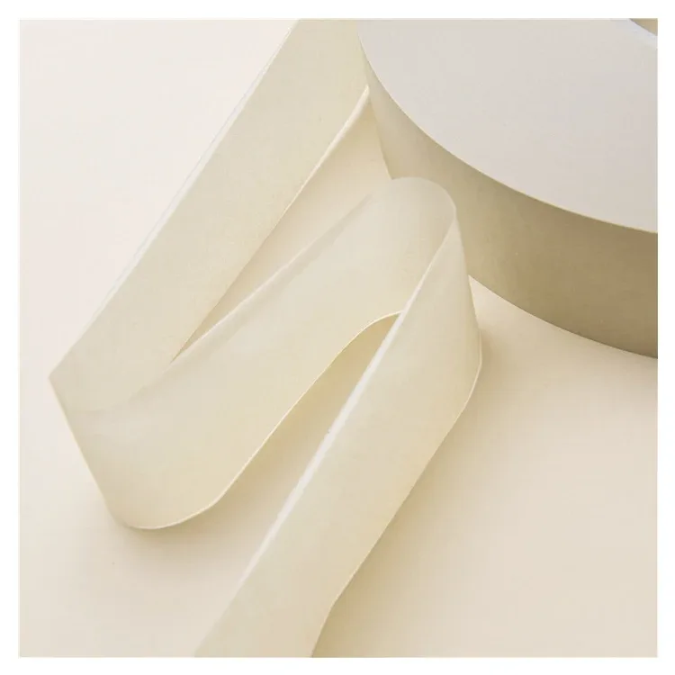 Thin translucent rolling paper strip unspooled from an industrial bobbin