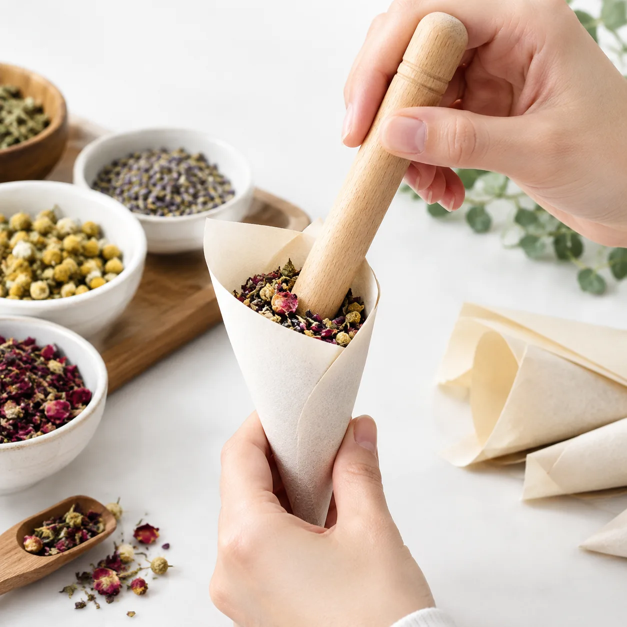 Hand using wooden packing stick to tamp flower evenly into pre-roll cone